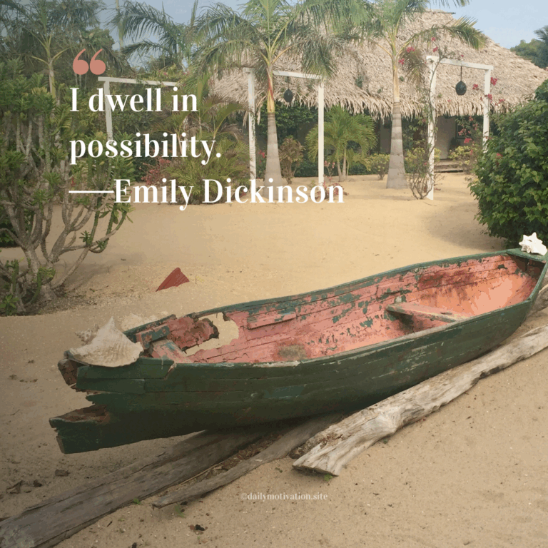Old wooden boat resting on sandy beach surrounded by palm trees and tropical plants.