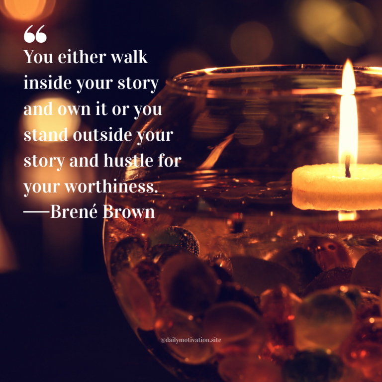 Lit candle floating in a glass bowl filled with smooth stones, surrounded by warm, blurred lights.