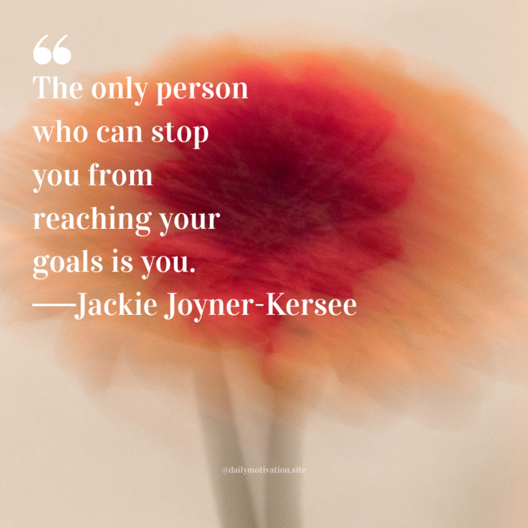 Soft-focus red flower with warm orange and beige tones blending into a dreamy background.