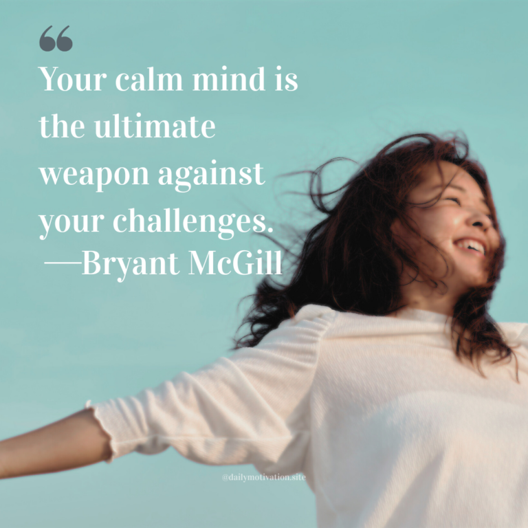 A woman smiling with arms outstretched as wind moves her hair against a clear blue sky.