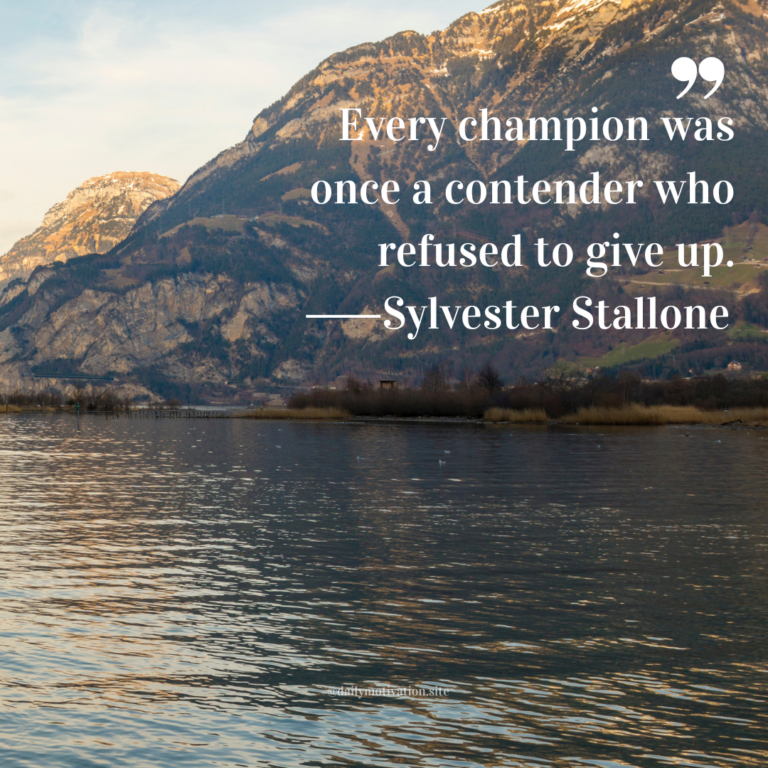Calm lake with gentle ripples reflecting tall mountains under a pale sky.